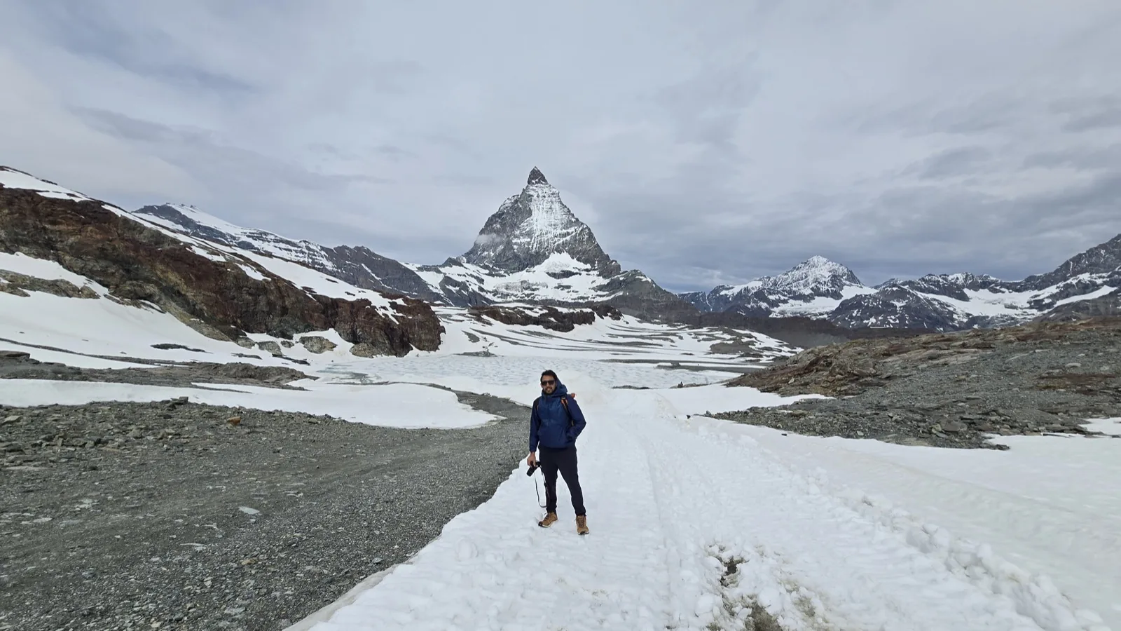 Shubham Gupta standing in front of the Matterhorn in a snowy alpine landscape